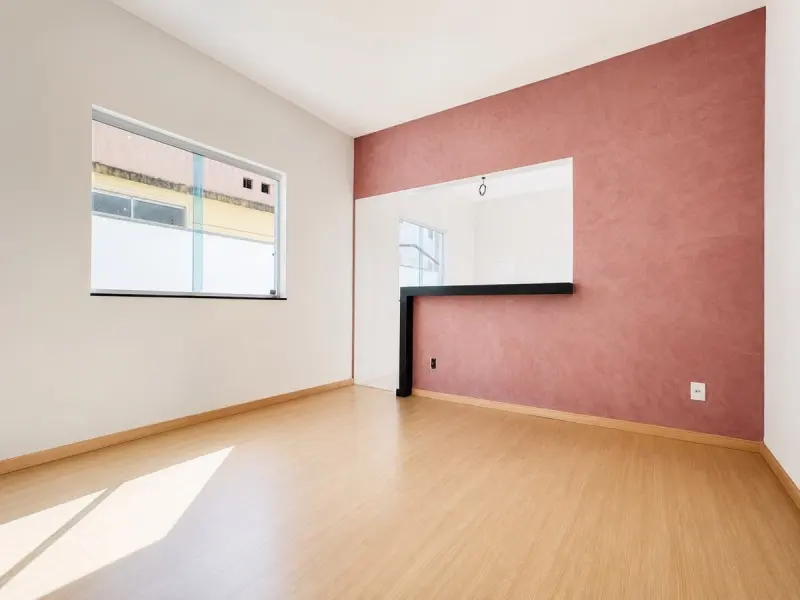 Sala integrada à cozinha americana com parede terracota e bancada preta